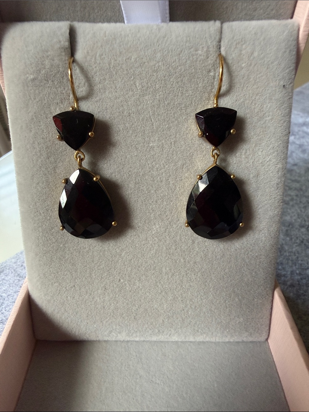 Gold-tone drop earrings featuring dark faceted gemstone dangles